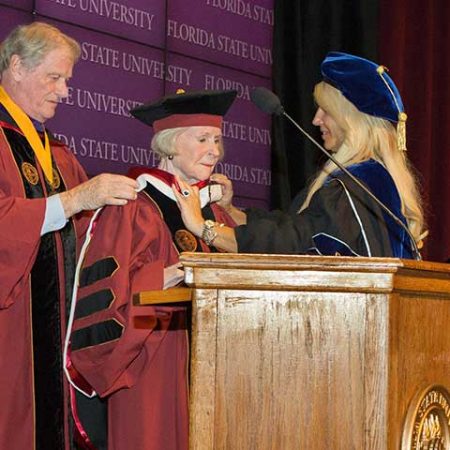 President John Thrasher hoods Grace Dansby as she receives an honorary doctorate Tuesday, Aug. 9.