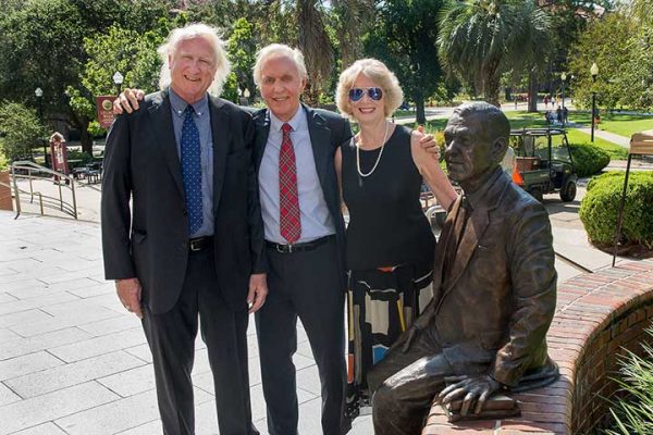 Chuck, Bob and Anne Strozier, children of President Strozier, with their father's statue.