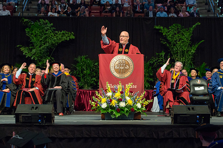 Alumnus Michael Goldberg leads the Saturday morning's commencement crowd in the war chant.