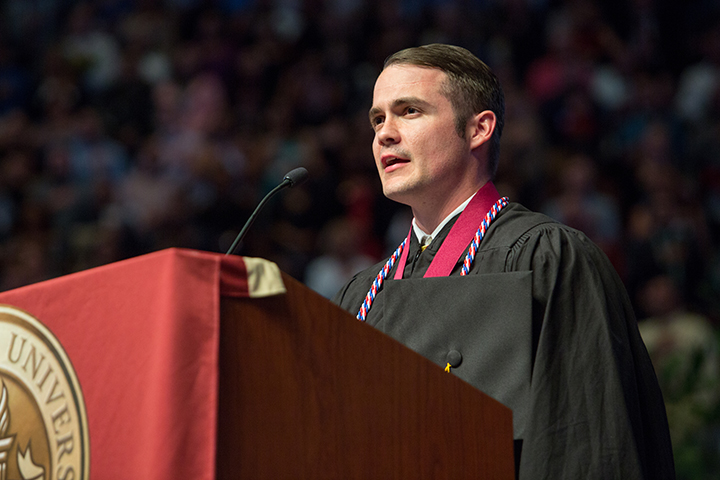 Student-veteran Ryan Taylor leads the crowd in the Pledge of Allegiance at Friday night's commencement ceremony.