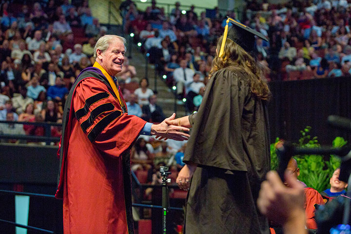 Summer commencement graduates were all smiles greeting President Thrasher as their names were announced.