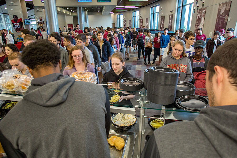 Student-athletes helped serve game day fare of hamburgers and hot dogs to more than 6,000 students at the Dunlap Champions Club Monday evening.