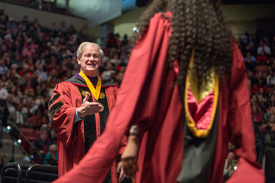 President Thrasher congratulates graduates as they walk on stage at fall commencement. (FSU Photography Services)