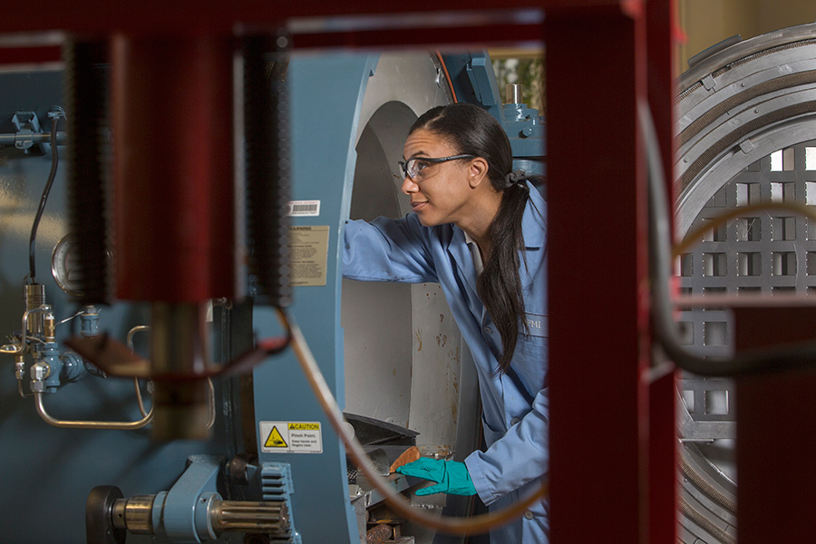 Graduate student Roslyn Shanklin examines the autoclave at the High-Performance Materials Institute.