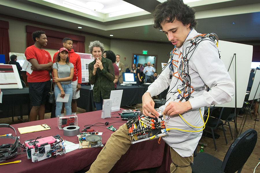 Lucas von Hollen of FSU’s School of Information configures his robot suit, which was crafted entirely of recycled and found materials.