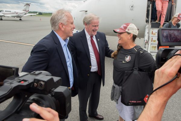 Chairman of the FSU Board of Trustees Ed Burr and President John Thrasher greet softball Coach Lonni Alameda at Tallahassee International Airport on June 6, 2018, following the team's victory at the 2018 Women's College World Series in Oklahoma City. (FSU Photography Services)