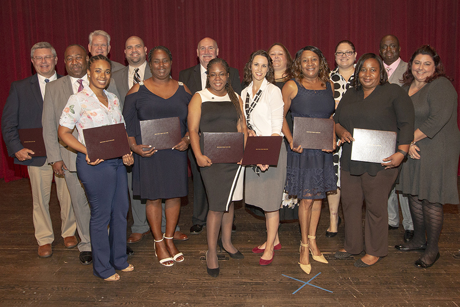 A small group of new CPM program graduates show off their certificates after the graduation ceremony Thursday, July 19, at Ruby Diamond Concert Hall.