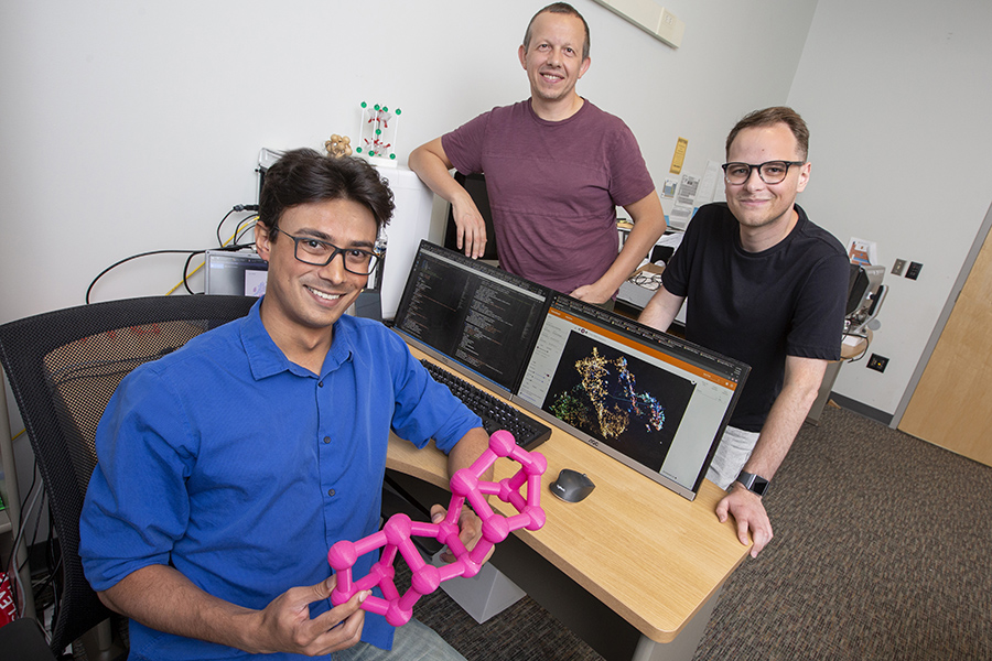 Doctoral student Kevin Ryan (seated) developed a machine learning model to predict new chemical compounds. Standing are Professor Michael Shatruk (left) and graduate student Jeff Lengyel (right).