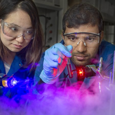 Graduate student Yan Zhou (left) and postdoctoral researcher Sahan Salpage use light to separate metal ions. This process, scientists believe, will be cheaper and greener than existing methods. (FSU Photography Services)