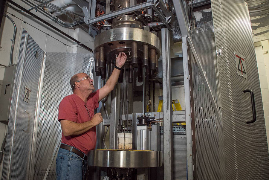 El ingeniero de investigación Charles Lamar English trabaja en un horno especializado que se utiliza para desarrollar bobinas magnéticas a partir del superconductor de alta temperatura Bi-2212, una versión del óxido de cobre bismuto estroncio calcio.  Foto de Stephen Bilenky/National MagLab.