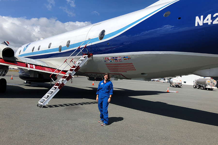 FSU postdoctoral researcher Heather Holbach poses in front of a NOAA WP-3D research plane, which is specially outfitted for hurricane hunting.