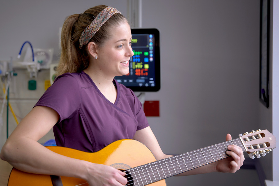 Ciele Gutierrez offers music therapy by singing or strumming a guitar. "I provide A cappella singing music," she said. "We use lullabies in the NICU because they are not complex, they’re repetitive, easy to listen to, and they're already promoting language development." (Photo: Tallahassee Memorial HealthCare)