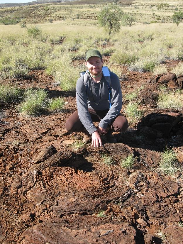 Researcher Chad Ostrander with a 2.7 billion-year-old fossilized stromatolite in Western Australia - strong evidence that they did indeed exist. Credit: Chad Ostrander, ASU