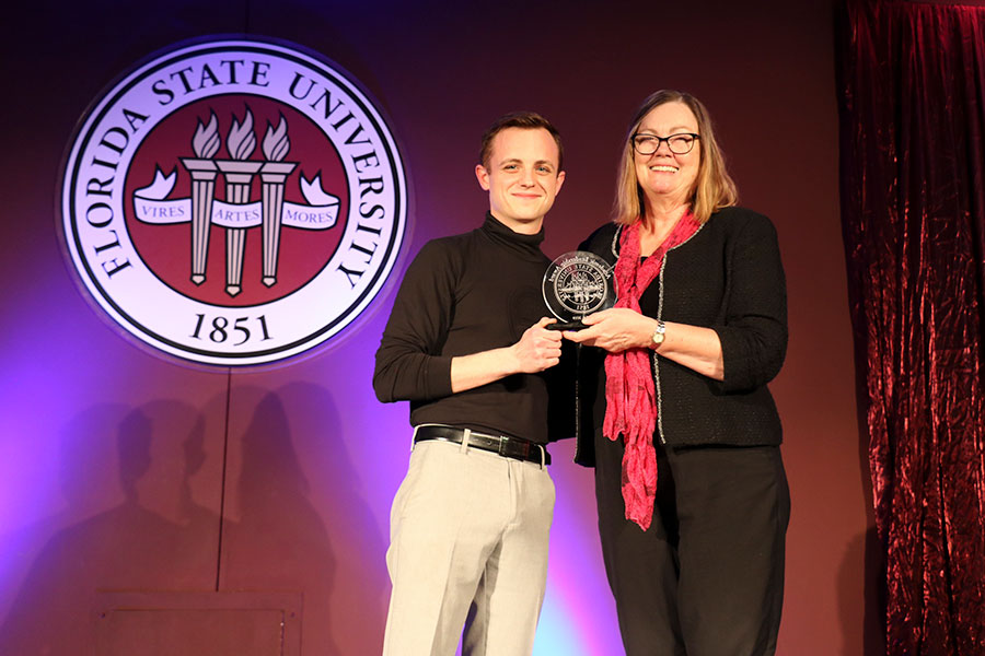 Dillon Gleenson accepts an Academic Leadership Award for Fine Arts from Provost Sally McRorie at the Leadership Awards Night April 9, 2019. (Photo: Division of Student Affairs)