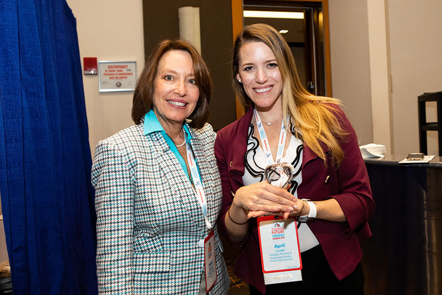 Nancy Roman, president and CEO of Partnership for a Healthier America, presents April Lovett, strategic planning and assessment analyst at FSU, with a crystal apple in recognition of Florida State University meeting PHA's Healthier Campus Initiative guidelines.