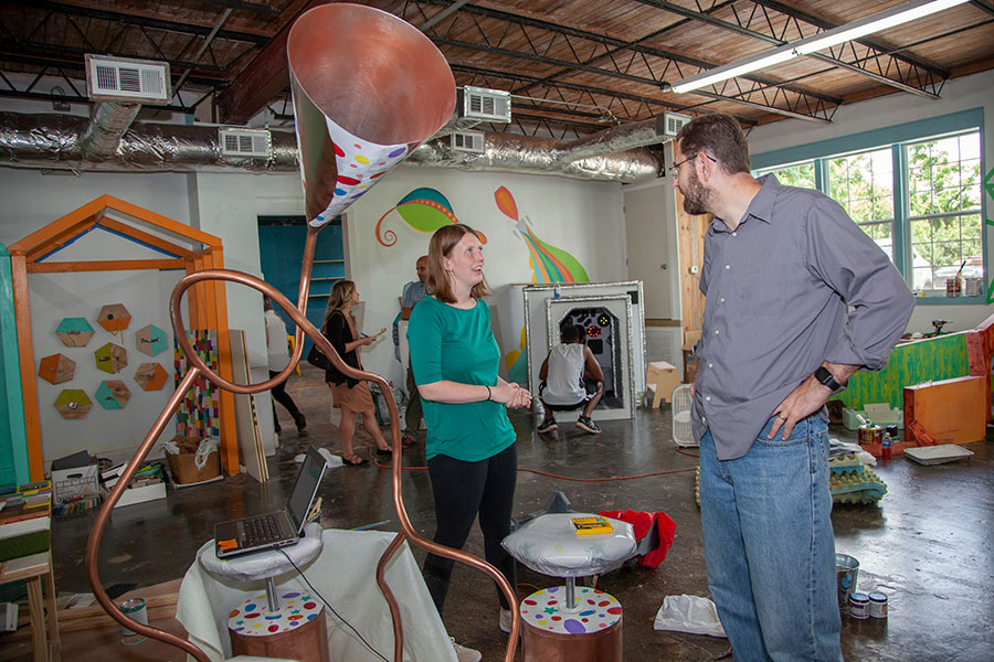 Associate Professor Jonathan Clark (right) and Maddie Wishart (left) discuss the logistics of Wishart's group project. Her group's creative play station is a horn surrounded by spinning seats. When the seats spin, the horn produces a medley of electronic sounds and bird noises. (Patricia Radulovich).