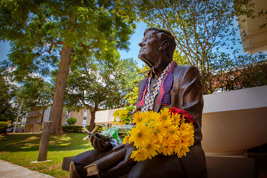 Flowers and bowties are left in tribute of President Emeritus Sandy D'Alemberte at his statue outside the College of Law May 21, 2019. (FSU Photography Services)