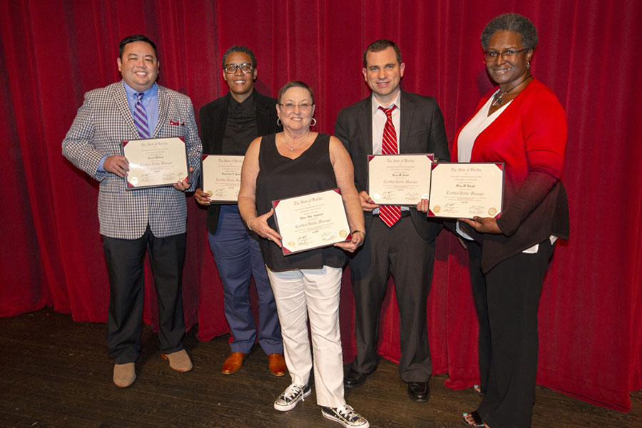 A group of graduates from the Florida Certified Public Manager (CPM) program poses with their certificates after the July 18 ceremony at Ruby Diamond concert hall. (FSU Photography Services)