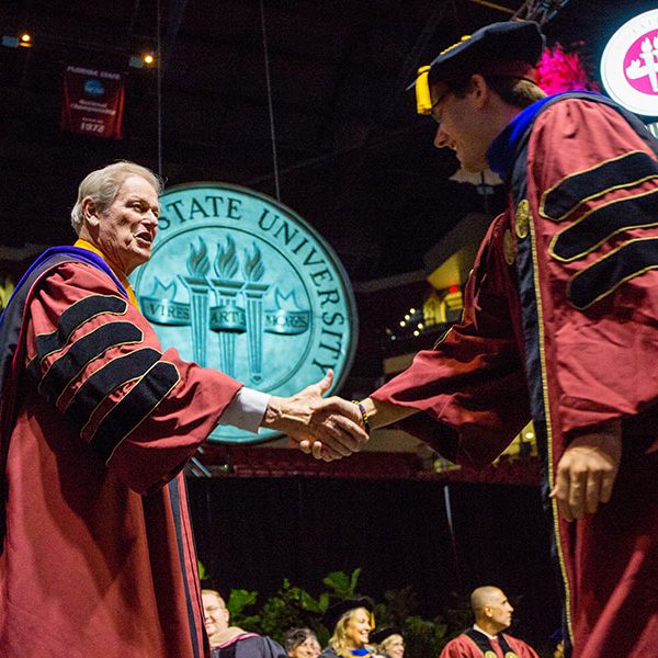 President John Thrasher congratulates a graduate during FSU's 2019 summer commencement. (FSU Photography Services)