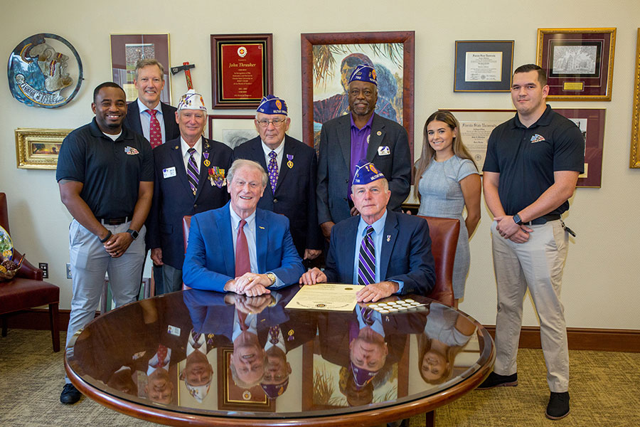 Seated, from left: FSU President John Thrasher and Rick Stanford, commander of the Tallahassee chapter of the Military Order of the Purple Heart. Standing, from left: Sean Williams, director of the FSU Veterans Student Union; Billy Francis, director of the Student Veterans Center; MOH chapter members Ken Swords, Mike Ford and Ned Hill; VSU assistant director Aaliyah Abarzua; and Matt Caraway, treasurer of the FSU Collegiate Veterans Association.