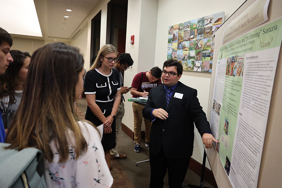 Senior Elias Larralde explains his project, "Melodies of Mirages: Exoticism, Folklore, and'performing' Santeria." (Bayard Stern)