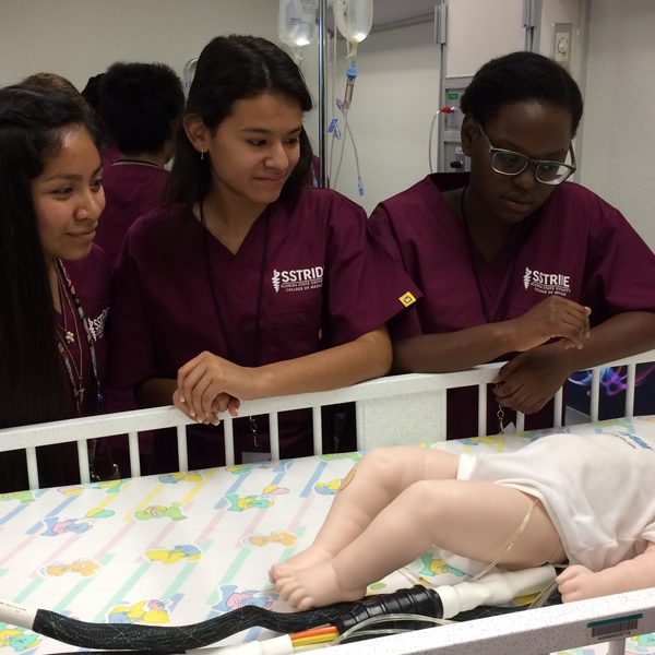 From left, SSTRIDE students Britney Garcia, Gisselle Nava and Ruth Bellevue observe how to take a brachial pulse in a baby. Courtesy of FSU College of Medicine