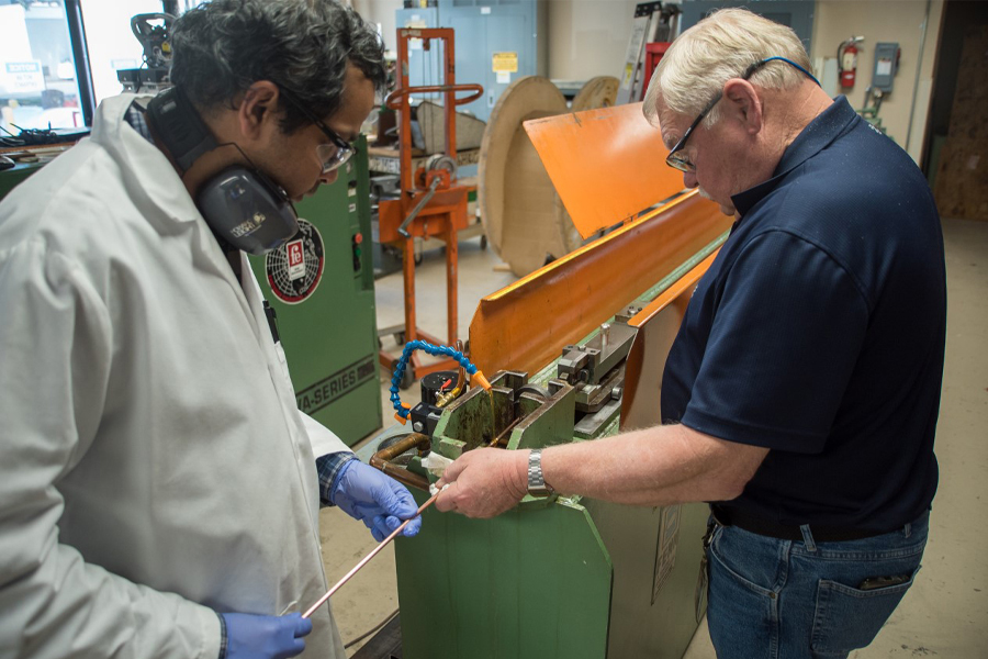 Research scientists Shreyas Balachandran, left, and William Starch draw lengths of niobium-tin superconducting wire at the Applied Superconductivity Center at the National High Magnetic Field Laboratory. A new grant of $1.5 million will allow the group to continue this research. Photo: Stephen Bilenky