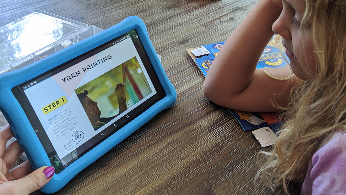 Maddie Cole a first grader in Cumming, GA watches a video on yarn painting featuring yarn artist HotTea