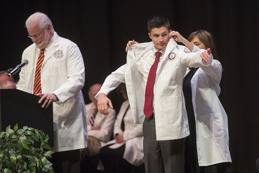 Jimmy Brown receives a white physician's coat during a 2017 ceremony at the FSU College of Medicine. Brown, a member of the M.D. Class of 2021, became the first student to recieve the Nancy Van Vessem, M.D. Memorial Scholarship. (FSU Photography Services)