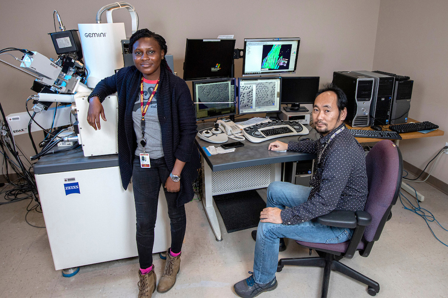 Abiola Temidayo Oloye, left, a fifth-year doctoral candidate and the lead author of a study published in Superconductor Science and Technology, at an electron microscope with Fumitake Kametani, an associate professor of mechanical engineering and principal investigator for the study at the FAMU-FSU College of Engineering. (Mark Wallheiser/FAMU-FSU College of Engineering)