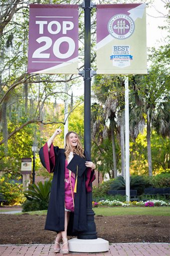 Jennifer Ralph, who graduated Saturday with a bachelor's degree in media communication studies, poses under the Top 20 signs in Westcott Plaza.