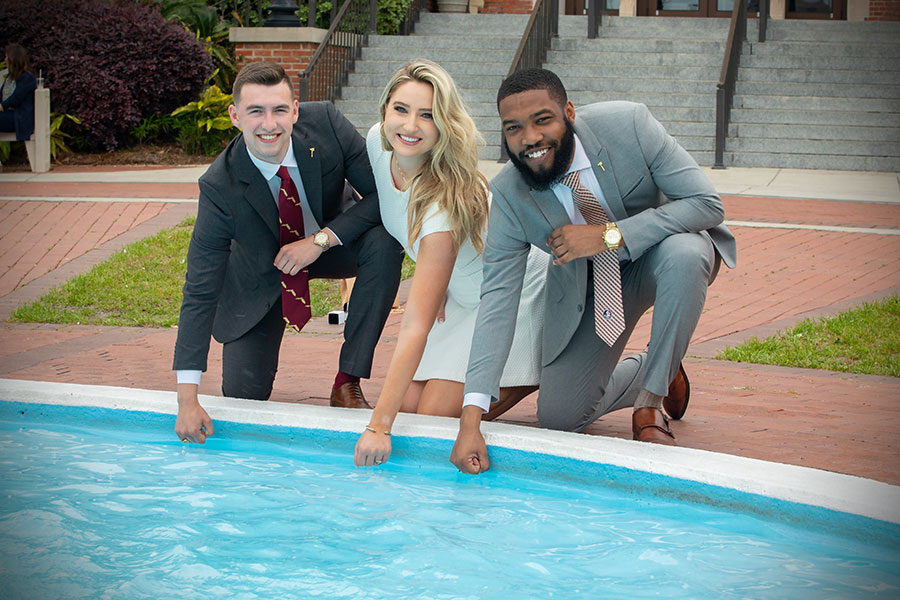 FSU graduates dip their class rings into Westcott Fountain during ring pick-up Thursday, April 8, 2021. (FSU Photography Services)