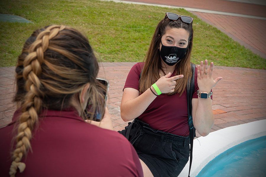 An FSU graduate picks up her class ring at Westcott Fountain Thursday, April 8, 2021. (FSU Photography Services)