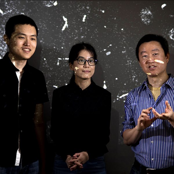 From left, postdoctoral researcher Yuan Tang, FSU graduate student Toshiaki Kanai, and FAMU-FSU College of Engineering professor Wei Guo discuss the movement of tracking particles in liquid helium of their particle tracking velocimetry system at the National High Magnetic Field Laboratory. (Mark Wallheiser/FAMU-FSU College of Engineering)