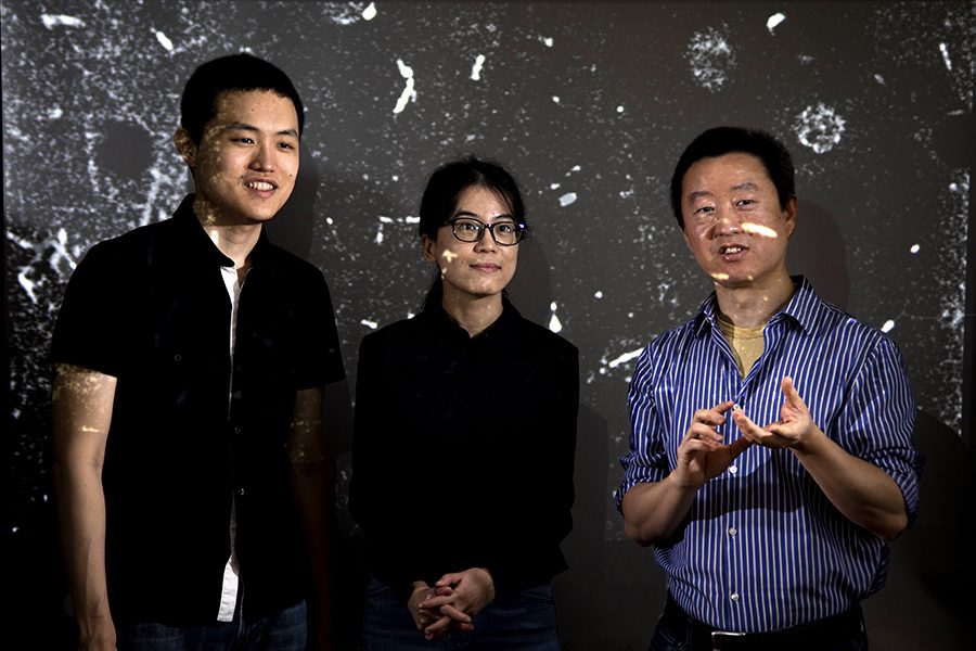 From left, postdoctoral researcher Yuan Tang, FSU graduate student Toshiaki Kanai, and FAMU-FSU College of Engineering professor Wei Guo discuss the movement of tracking particles in liquid helium of their particle tracking velocimetry system at the National High Magnetic Field Laboratory. (Mark Wallheiser/FAMU-FSU College of Engineering)