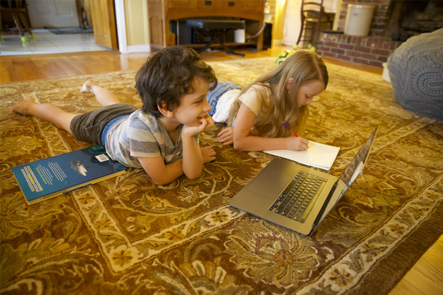 A first-grade student and fourth-grade student learning from home through the digital academy at Gilchrist Elementary School. (Courtesy of Robert Schoen)