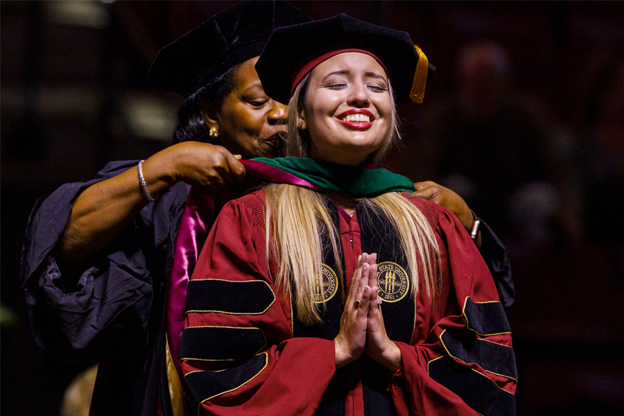 Fort Pierce campus dean Juliette Lomax Homier presents Jessica Gonzalez-Lorente with her academic hood at the graduation ceremony for the Florida State University College of Medicine M.D. Class of 2021. (Colin Hackley/College of Medicine)