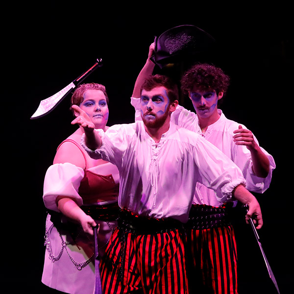 Karsyn Fletcher, Sam Abel and Jacob Tillman juggling knives as ghostly pirates.