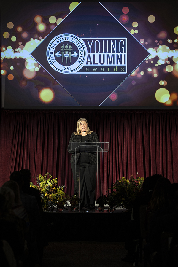 Julie Decker, President, and CEO of the Alumni Association, as she addressed event attendees.