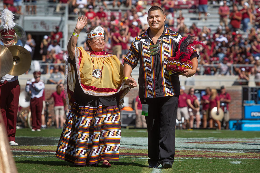 Connie Gowen, who became the Seminole Tribe's first princess in 1957, is escorted by Kyle Doney during FSU Homecoming festivities Oct. 23, 2021, at Doak Campbell Stadium. (FSU Photography Services)