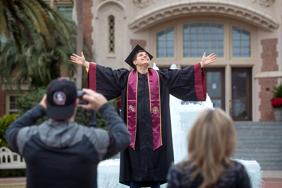 An FSU graduate celebrates with a traditional photo at the Westcott Fountain Dec. 9, 2021. (FSU Photography Services)