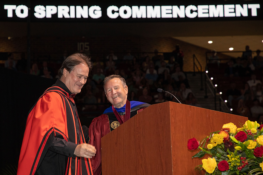 Mark Riley, dean of The Graduate School, and President McCullough share a laugh during FSU's spring commencement Friday, April 29, 2022. (FSU Photography Services)