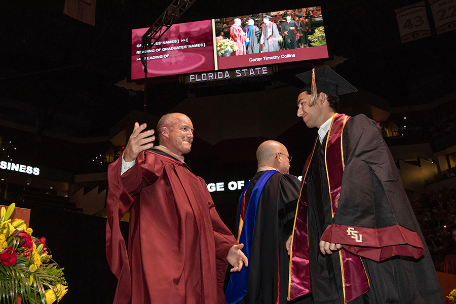 Peter Collins, chair of the FSU Board of Trustees, congratulates his son, Carter, at the afternoon ceremony Friday, April 29, 2022. (FSU Photography Services)