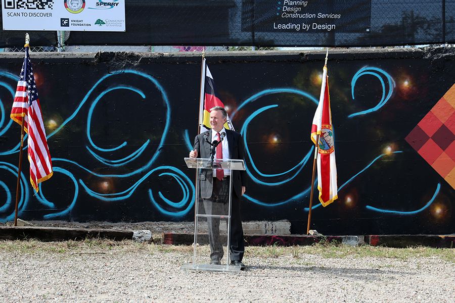 President Richard McCullough helps celebrate the unveiling of a mural created by members of the Seminole Tribe of Florida.