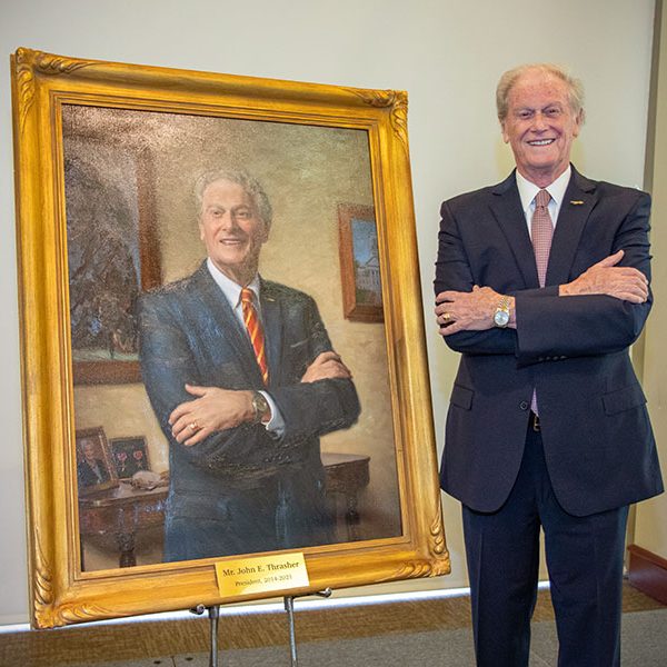President Emeritus John Thrasher poses with his portrait during the unveiling ceremony April 25, 2022. (FSU Photography Services)