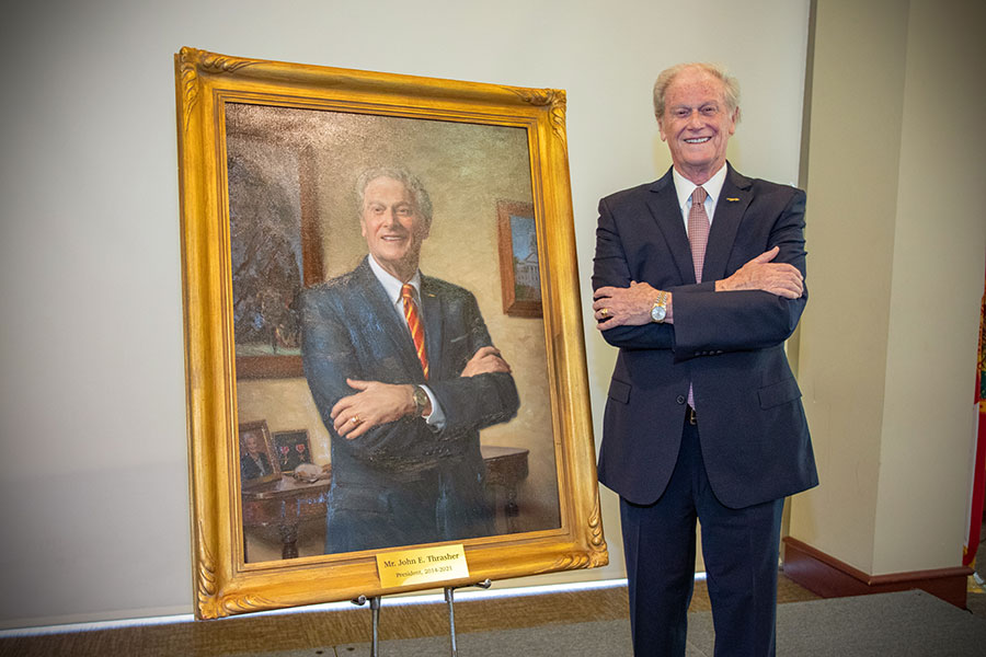 President Emeritus John Thrasher poses with his portrait during the unveiling ceremony April 25, 2022. (FSU Photography Services)