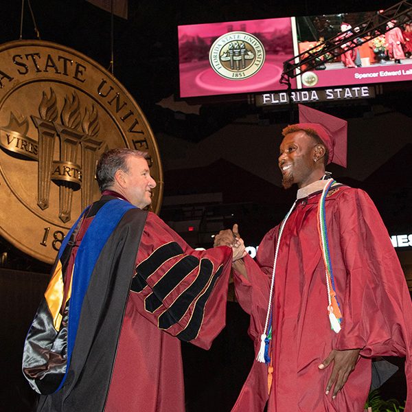 President Richard McCullough and student during summer commencement ceremony, July 29, 2022