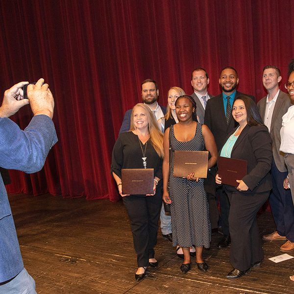 A group of graduates from the Florida Certified Public Manager (CPM) program pose with their certificates after the July 21 ceremony at Ruby Diamond concert hall. (FSU Photography Services)