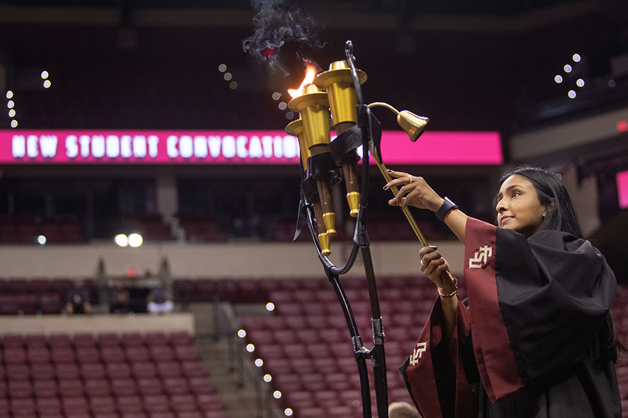 Senior Dhenu Patel lights a torch at New Student Convocation on Aug. 21, 2022, at the Donald L. Tucker Civic Center. (FSU Photography Services)