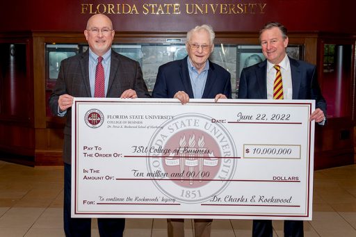 Michael Hartline, left, dean of the Florida State University College of Business, and FSU President Richard McCullough, right, join Charles Rockwood during a check presentation on Tuesday, Aug. 30. The gift from Rockwood and his late wife, the trailblazing Persis Rockwood, continued a legacy of major donations from the couple to the college and university.
